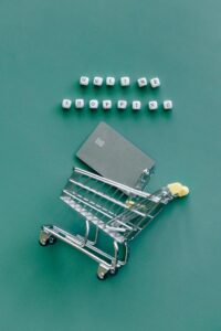 A miniature shopping cart with a credit card illustrates online shopping trends.